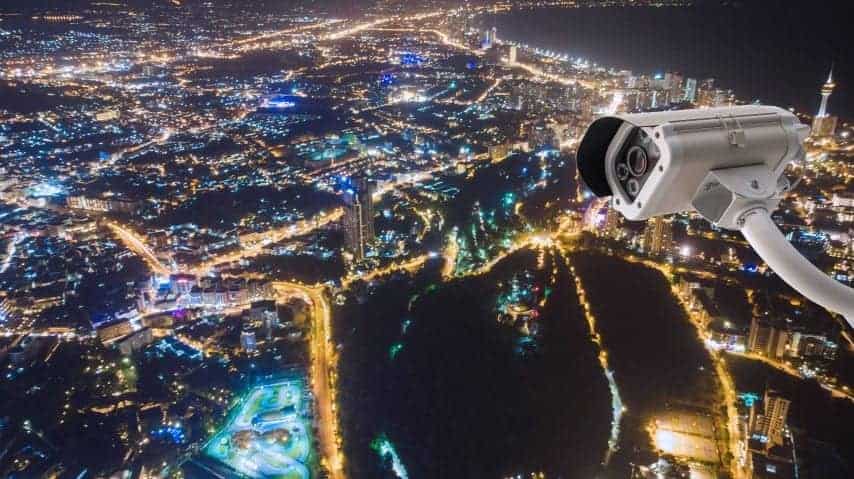 High-resolution CCTV camera monitoring city at night, ideal for network data surveillance and security.
