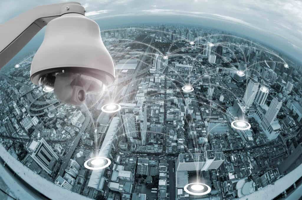 CCTV camera over high-rise cityscape with digital network connections.
