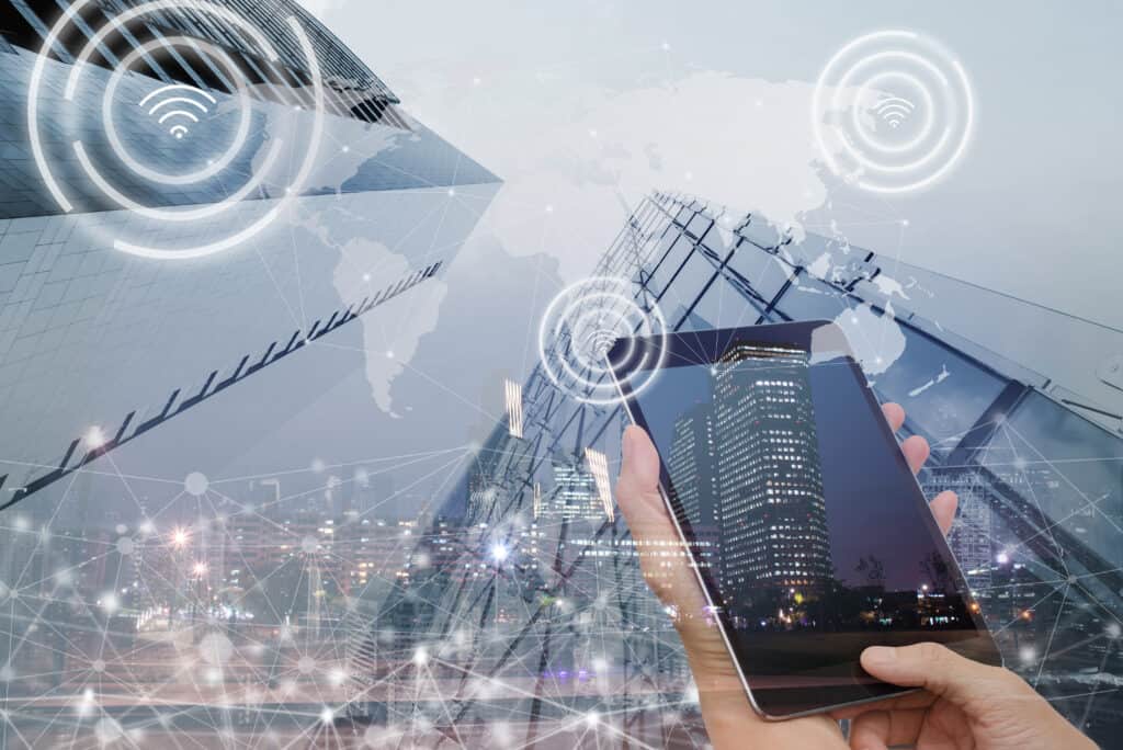 Person holding a smartphone with network icons over a city skyline
