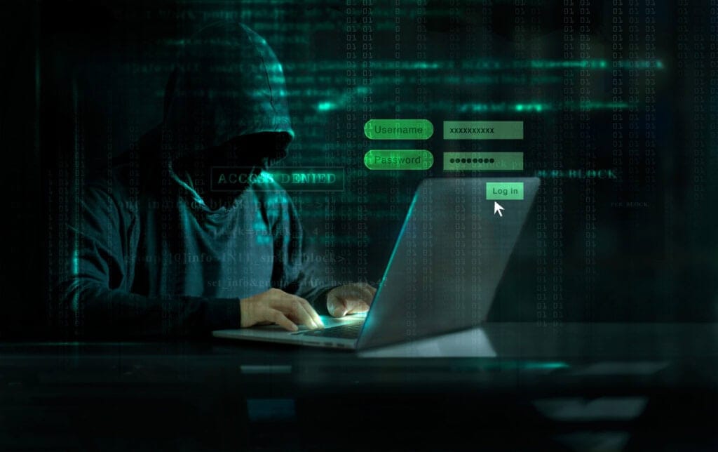 Dark figure hacking computer with login screen and "Access Denied" message.