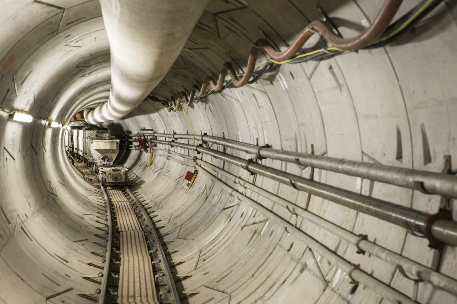 Completed tunnel section on the Thames Tideway Tunnel showing cabling and pipework installed along the tunnel wall