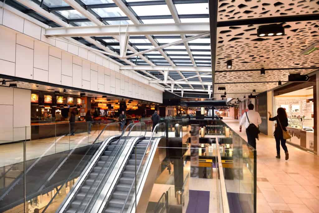 Bright indoor shopping centre with advanced network cabling and data systems for retail.