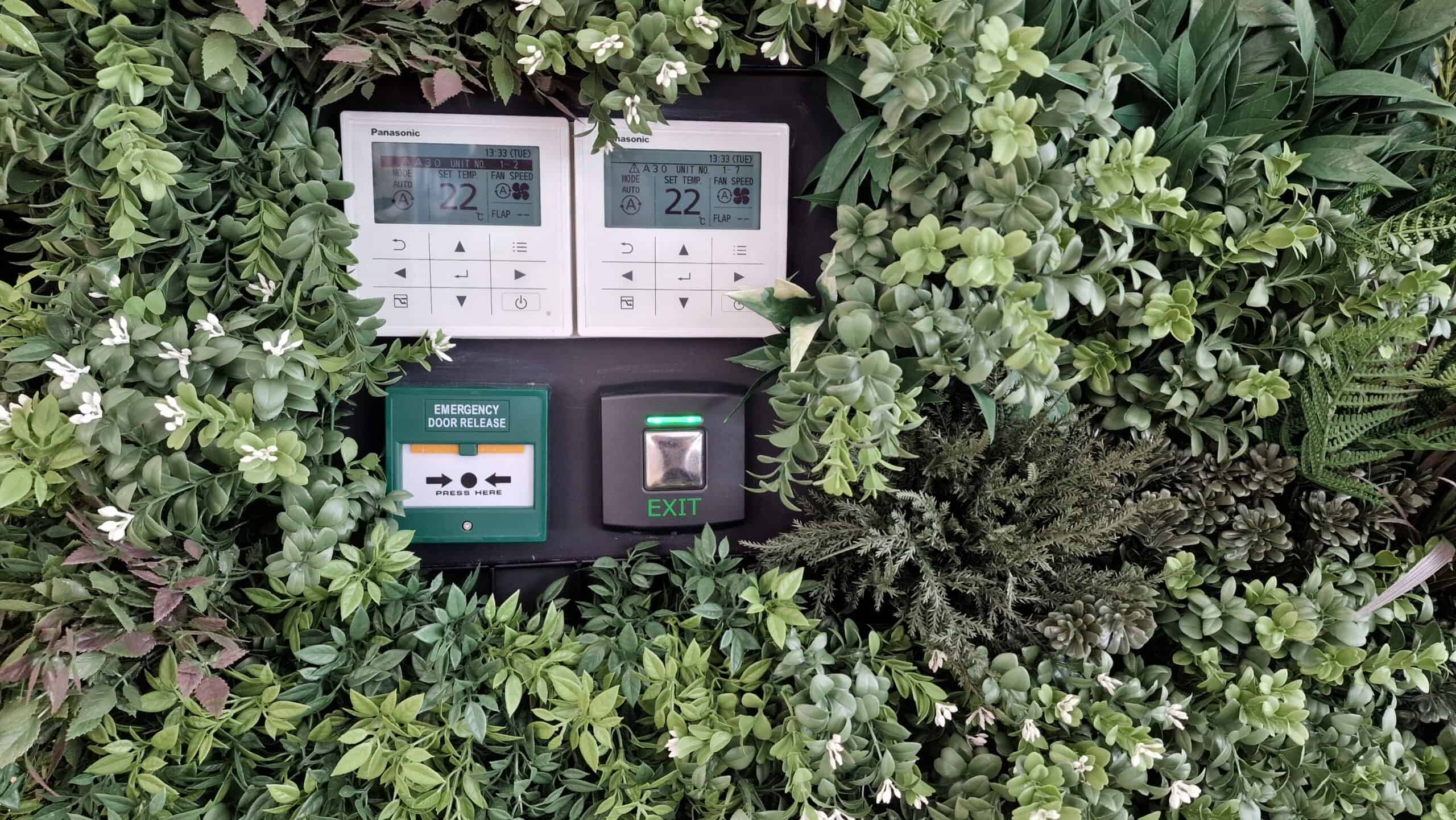 Accessible exit control and emergency door release integrated into a planted wall at Babylon Health