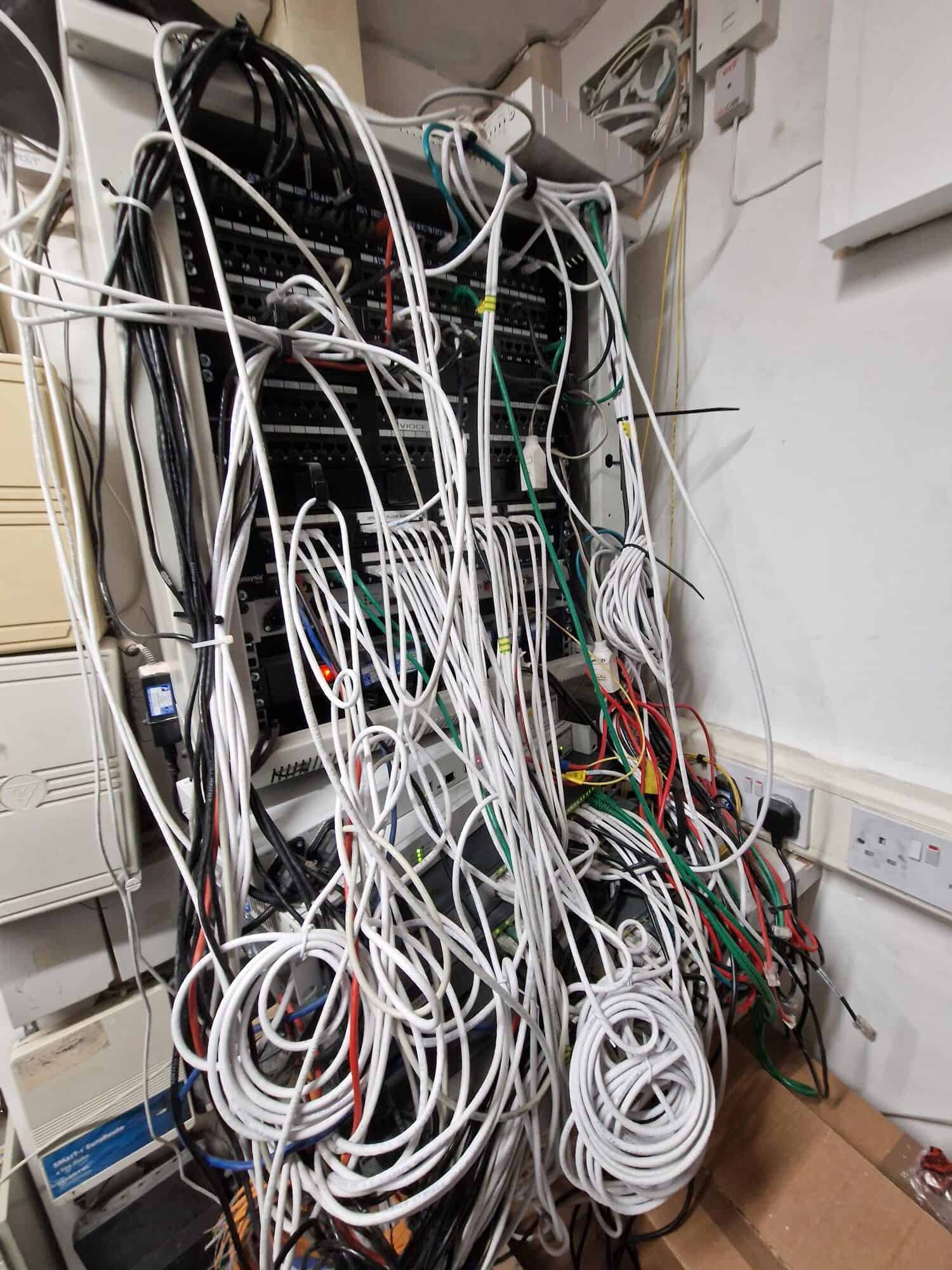Legacy network switches and cabling before ACCL's infrastructure upgrade at a Chestertons branch