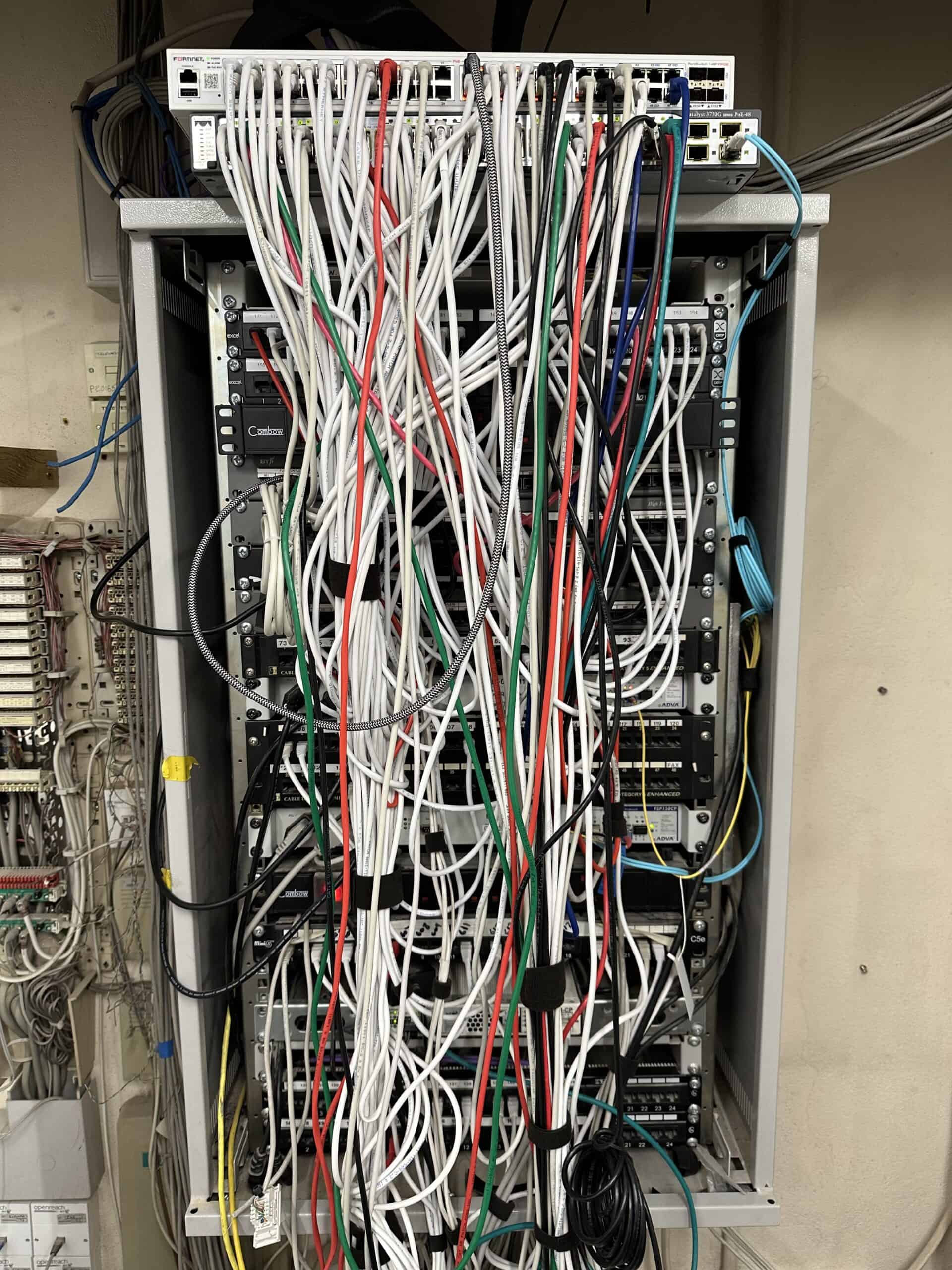 Legacy cabling and switching equipment before ACCL's infrastructure upgrade across the Chestertons estate