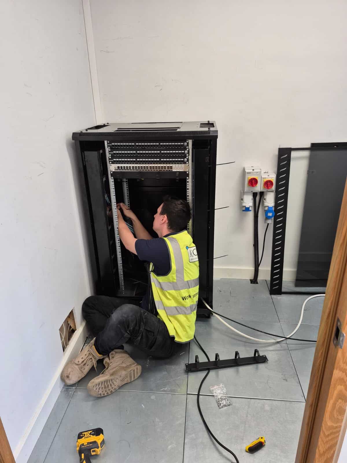 ACCL engineer installing and patching the new communications cabinet at Zaiwalla & Co, Holborn