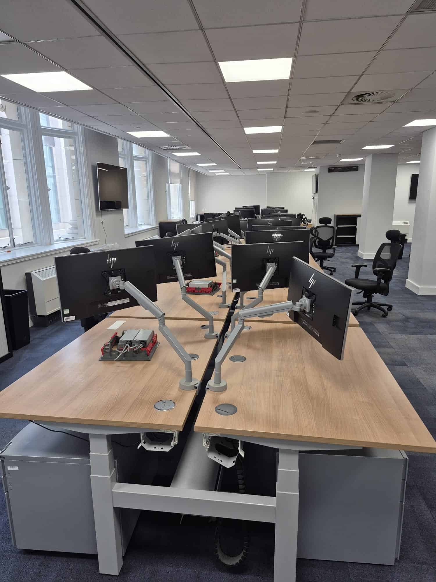 Modern office with multiple monitors and network cabling equipment.