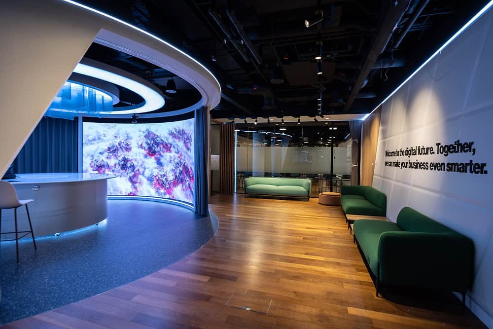 Interior of the Verizon Business London Hub with curved video wall and seating area