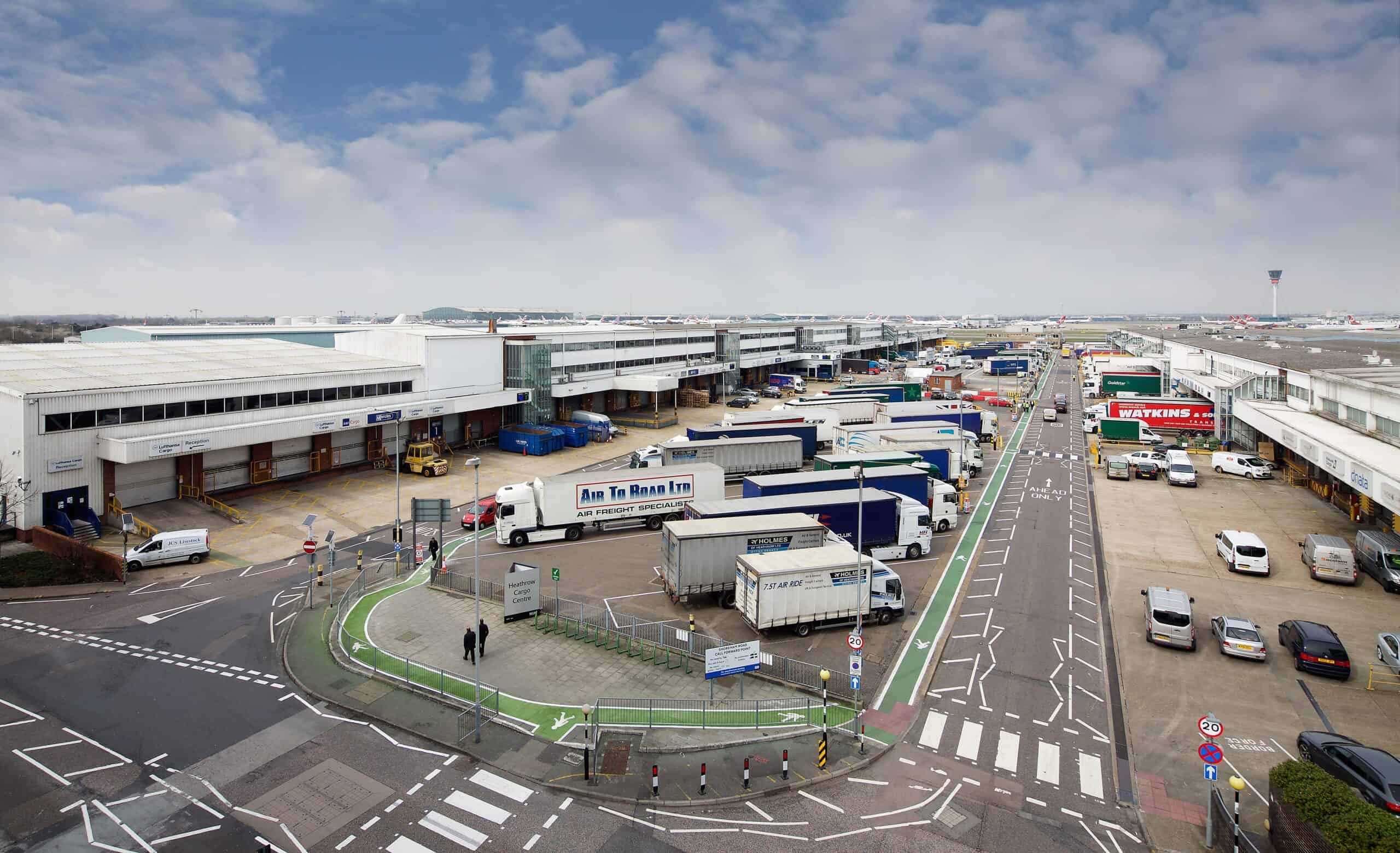 Large logistics warehouse with data cabling infrastructure and trucks.