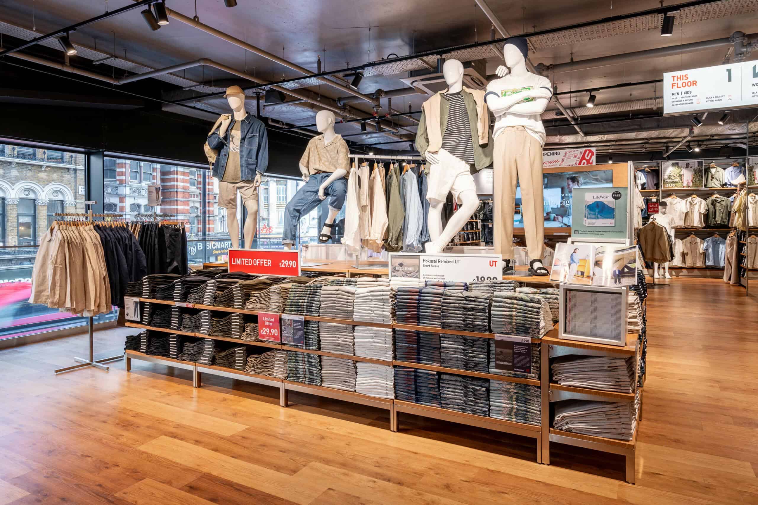 Interior sales floor of UNIQLO's Oxford Street flagship store in London, with Oxford Street visible through the windows