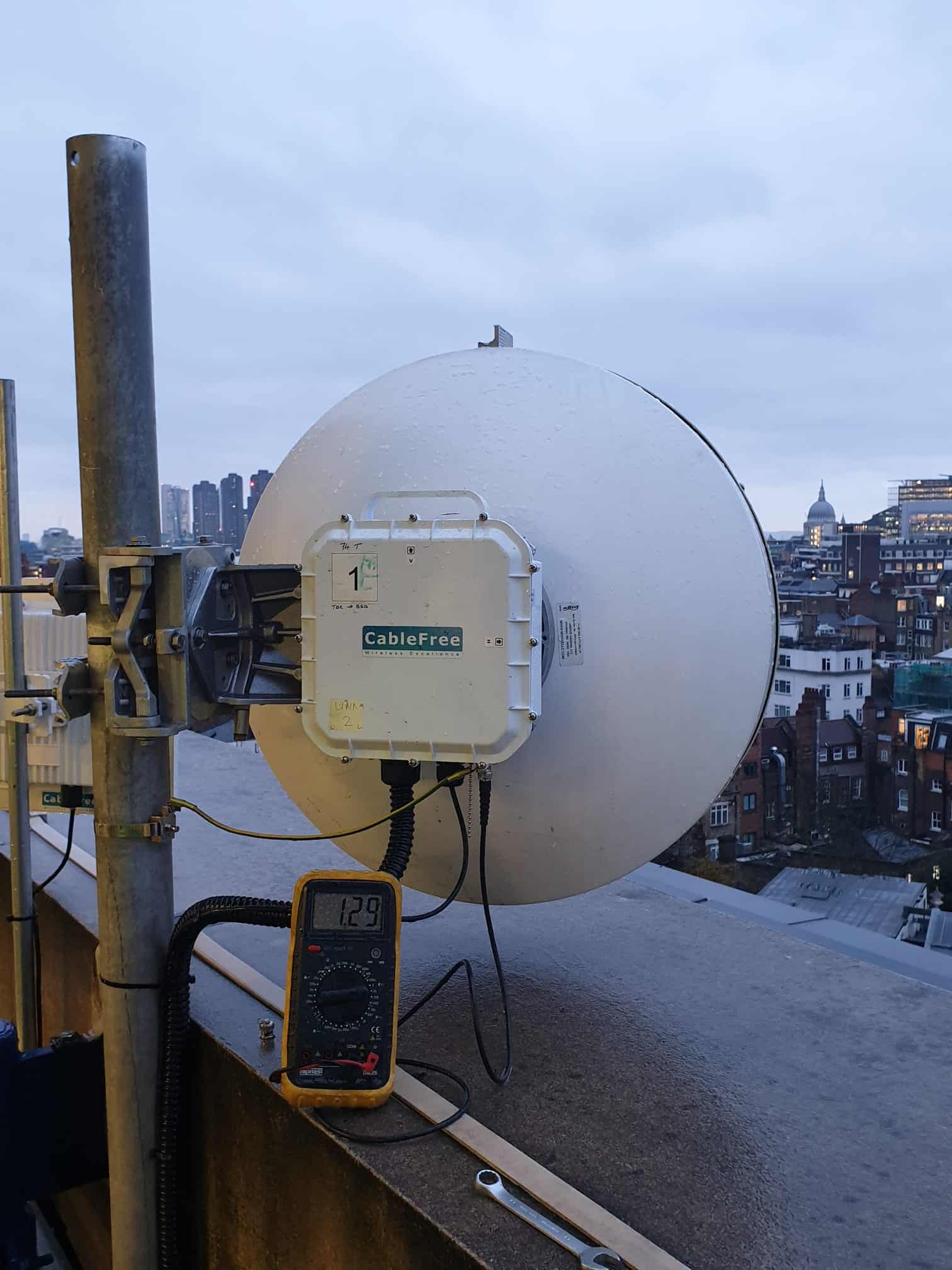 CableFree rooftop wireless link being tested with a multimeter for the Warner Bros network